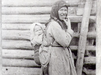 Женщина-удмуртка в традиционном наряде, с ребенком в заплечной сумке. УАССР, Шарканский р-н, 1938 г.